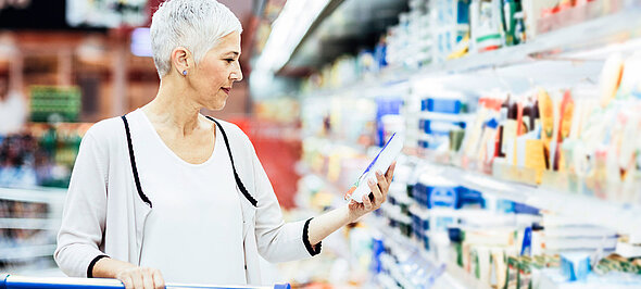 Vrouw bij het gekoelde schap in de supermarkt