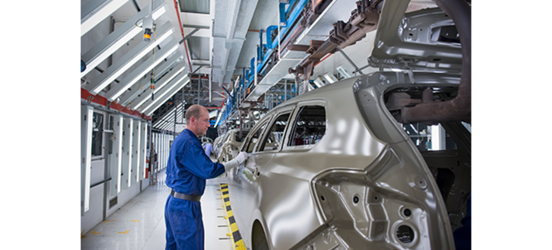 Man werkt aan een auto op een assemblagelijn